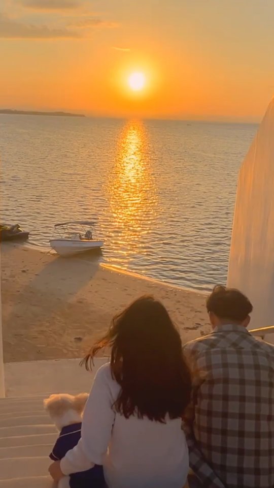 Couple watching a golden sunset from the clifftop stairs at Dasol Beach Villas